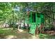 Backyard playhouse features bright paint, a ladder, and a fun climbing wall at 3255 Marine Rd, Cumming, GA 30041