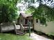 Back of the house with a deck and access stairs to the backyard, surrounded by greenery at 5820 Elm Tree Dr, Buford, GA 30518