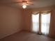 Simple bedroom featuring neutral carpet and curtains allowing for natural lighting and a ceiling fan at 5820 Elm Tree Dr, Buford, GA 30518