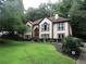 Charming two-story home featuring a manicured lawn and a welcoming front entrance, set amongst mature trees at 5820 Elm Tree Dr, Buford, GA 30518