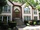 Beautiful home showcasing front door with an arched entry, manicured shrubs and stone steps at 5820 Elm Tree Dr, Buford, GA 30518