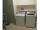 Laundry room with a washer and dryer set, and a shelf on the wall for storage at 5820 Elm Tree Dr, Buford, GA 30518