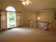 Bright loft area with large windows, neutral carpet, and decorative lighting overlooking a staircase at 5820 Elm Tree Dr, Buford, GA 30518