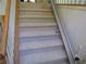Carpeted staircase equipped with a chair lift for enhanced accessibility at 5820 Elm Tree Dr, Buford, GA 30518