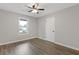 Cozy bedroom featuring wood floors, a ceiling fan, and a bright window at 2310 Whitehead Place Dr, Suwanee, GA 30024