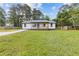 Charming single-story home featuring a lovely front porch, a well-maintained lawn and a freshly poured concrete driveway at 2310 Whitehead Place Dr, Suwanee, GA 30024