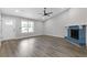 Spacious living room boasts new floors, modern fan, painted brick fireplace, and entry to front door at 2310 Whitehead Place Dr, Suwanee, GA 30024