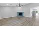 Spacious living room boasts new floors, modern fan, painted brick fireplace, and entry to backyard at 2310 Whitehead Place Dr, Suwanee, GA 30024