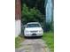 View of the front of the house and overgrown driveway with the car parked there at 3363 Lake Valley Nw Rd, Atlanta, GA 30331