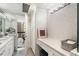 Bright bathroom featuring a vanity area, white cabinets, countertop, decorative wallpaper and a peek at the city view at 145 15Th Ne St # 1430, Atlanta, GA 30309