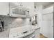 Kitchen featuring a white electric stovetop, a microwave, and marble backsplash at 145 15Th Ne St # 1430, Atlanta, GA 30309