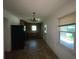 View of dining room space with a chandelier, window to let in natural light and dark kitchen appliances at 2369 Christian Cir, Covington, GA 30016