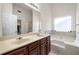 Bright bathroom with double sinks, large mirror, separate shower and tub under a window at 305 Hidden Creek Ln, Canton, GA 30114