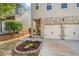 Close-up of a home's inviting entrance, showcasing a two-car garage and landscaped flower bed at 305 Hidden Creek Ln, Canton, GA 30114