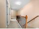 Hallway with carpet, wood banister, natural light, and white doors at 305 Hidden Creek Ln, Canton, GA 30114
