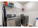 Laundry room with modern washer and dryer set, storage shelf, and white walls at 305 Hidden Creek Ln, Canton, GA 30114