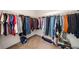 Walk-in closet filled with clothing on rods and shoes in boxes on the floor at 305 Hidden Creek Ln, Canton, GA 30114