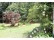 Sprawling backyard featuring lush greenery, mature trees, and well-maintained lawn at 405 Mallory Cir, Loganville, GA 30052