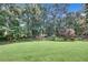 Expansive backyard featuring a vast lawn surrounded by mature trees, offering privacy and shade at 405 Mallory Cir, Loganville, GA 30052