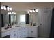 Bright bathroom with double vanity sinks, white cabinets, and large mirrors at 405 Mallory Cir, Loganville, GA 30052