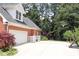 Brick home featuring a driveway, an attached two-car garage and mature trees at 405 Mallory Cir, Loganville, GA 30052