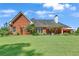 Brick home's exterior view showcasing a manicured lawn and covered patio, blending indoor-outdoor living at 405 Mallory Cir, Loganville, GA 30052