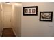 Hallway with hardwood floors and two Gathering pictures hanging on the wall at 405 Mallory Cir, Loganville, GA 30052