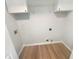 Functional laundry room with wood-look floors, shelving, and connections for your laundry appliances at 4133 Rosedown Nw Ct, Kennesaw, GA 30144