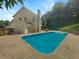 Backyard swimming pool with surrounding concrete patio, trees, and a lush green hillside at 4133 Rosedown Nw Ct, Kennesaw, GA 30144