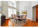 Formal dining room featuring high ceilings, hardwood floors, an elegant table, and large windows at 5832 Sloane St, Douglasville, GA 30135