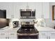 Close-up of a modern kitchen featuring white cabinets, stainless steel appliances, and stylish countertops at 5832 Sloane St, Douglasville, GA 30135