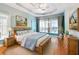 Serene main bedroom featuring tray ceilings, soft blue walls, and large windows providing ample natural light at 5832 Sloane St, Douglasville, GA 30135