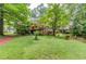 Spacious backyard featuring a deck, tree swing, and seating area, great for outdoor entertaining at 2291 Smokehouse Path, Lawrenceville, GA 30044