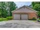 Spacious two-car brick garage with neutral doors, surrounded by greenery and a concrete driveway at 2291 Smokehouse Path, Lawrenceville, GA 30044