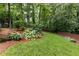 Beautifully landscaped backyard with vibrant greenery, a manicured lawn, and a charming wooden fence at 3072 Dale Ne Dr, Atlanta, GA 30305