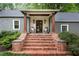 Inviting front porch with brick steps, seating, and stylish lighting fixtures at 3072 Dale Ne Dr, Atlanta, GA 30305