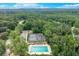 Aerial shot showcasing community pool, tennis courts and more amenities nestled among mature trees and picturesque landscape at 2105 Huntington Hills Trce, Buford, GA 30519
