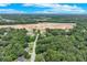 Expansive aerial view reveals a property near a new development site surrounded by dense greenery and clear skies at 2105 Huntington Hills Trce, Buford, GA 30519