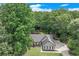 Scenic aerial shot of a charming home with lush backyard, nestled among dense trees and a winding driveway at 2105 Huntington Hills Trce, Buford, GA 30519