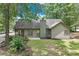 Lush backyard with mature trees, green grass, and home exterior at 2105 Huntington Hills Trce, Buford, GA 30519