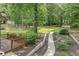 Landscaped backyard featuring a deck, stone walkway, and lush foliage, perfect for outdoor enjoyment and relaxation at 2105 Huntington Hills Trce, Buford, GA 30519
