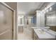 Well-lit bathroom with double vanity, bathtub, and glass shower enclosure at 2105 Huntington Hills Trce, Buford, GA 30519