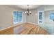 Cozy dining area with hardwood floors, a modern chandelier, and large windows that offer plenty of natural light at 2105 Huntington Hills Trce, Buford, GA 30519