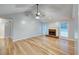 Spacious living room with gleaming hardwood floors, a ceiling fan, and a charming fireplace at 2105 Huntington Hills Trce, Buford, GA 30519