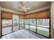 Relaxing sunroom with tiled floor, multiple windows, and a ceiling fan to maintain a comfortable atmosphere at 2105 Huntington Hills Trce, Buford, GA 30519