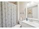Well-lit bathroom with patterned shower curtain, white vanity, and framed mirror above the sink at 4365 Mantle Ridge Dr, Cumming, GA 30041