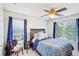 Well-lit bedroom with two windows, ceiling fan, and a bed with blue covers at 4365 Mantle Ridge Dr, Cumming, GA 30041