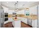 Bright kitchen featuring white cabinets, granite countertops, stainless steel appliances, and a central island at 4365 Mantle Ridge Dr, Cumming, GA 30041