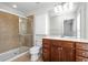 Bathroom featuring tiled shower, vanity with white countertop and wood cabinets and a large mirror at 4874 Seldon Se Way, Smyrna, GA 30080