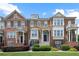 Attractive townhome featuring a mix of brick and stone facade, complemented by lush green lawn and manicured landscaping at 4874 Seldon Se Way, Smyrna, GA 30080